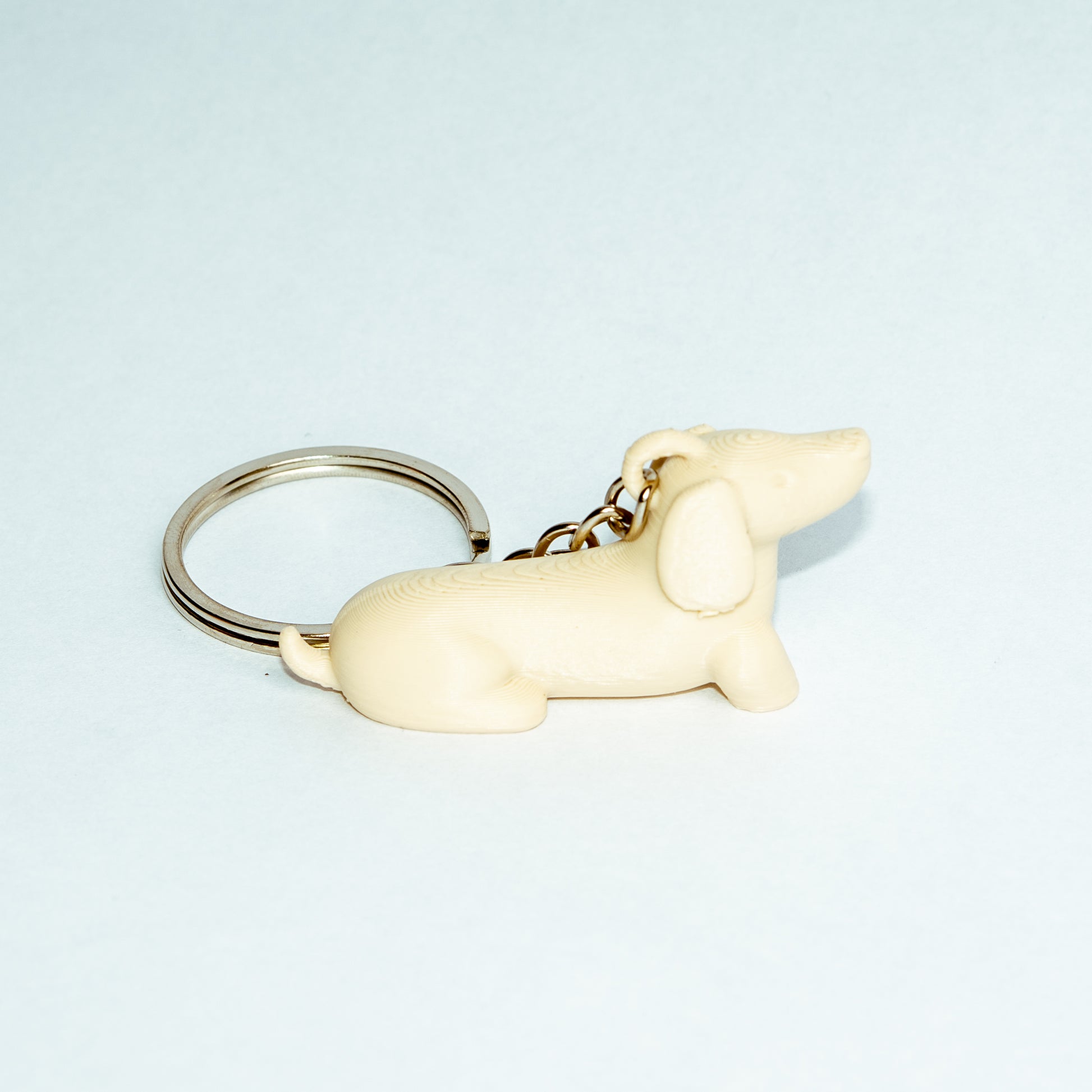 Llavero Benny en color beige de la marca CuatroCeroTres, accesorio decorativo con diseño de personaje en fondo blanco.