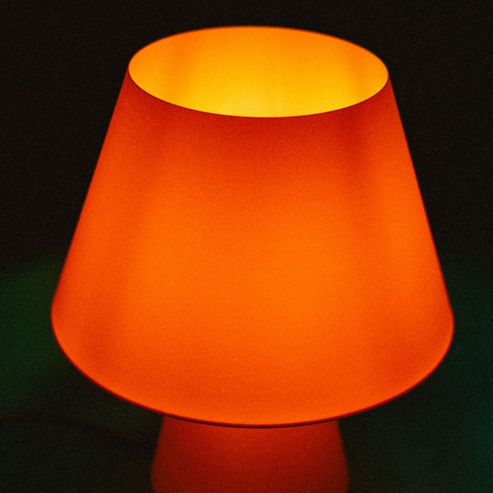 Lámpara Fome naranja de CuatroCeroTres con diseño moderno, iluminando un espacio interior con luz cálida
