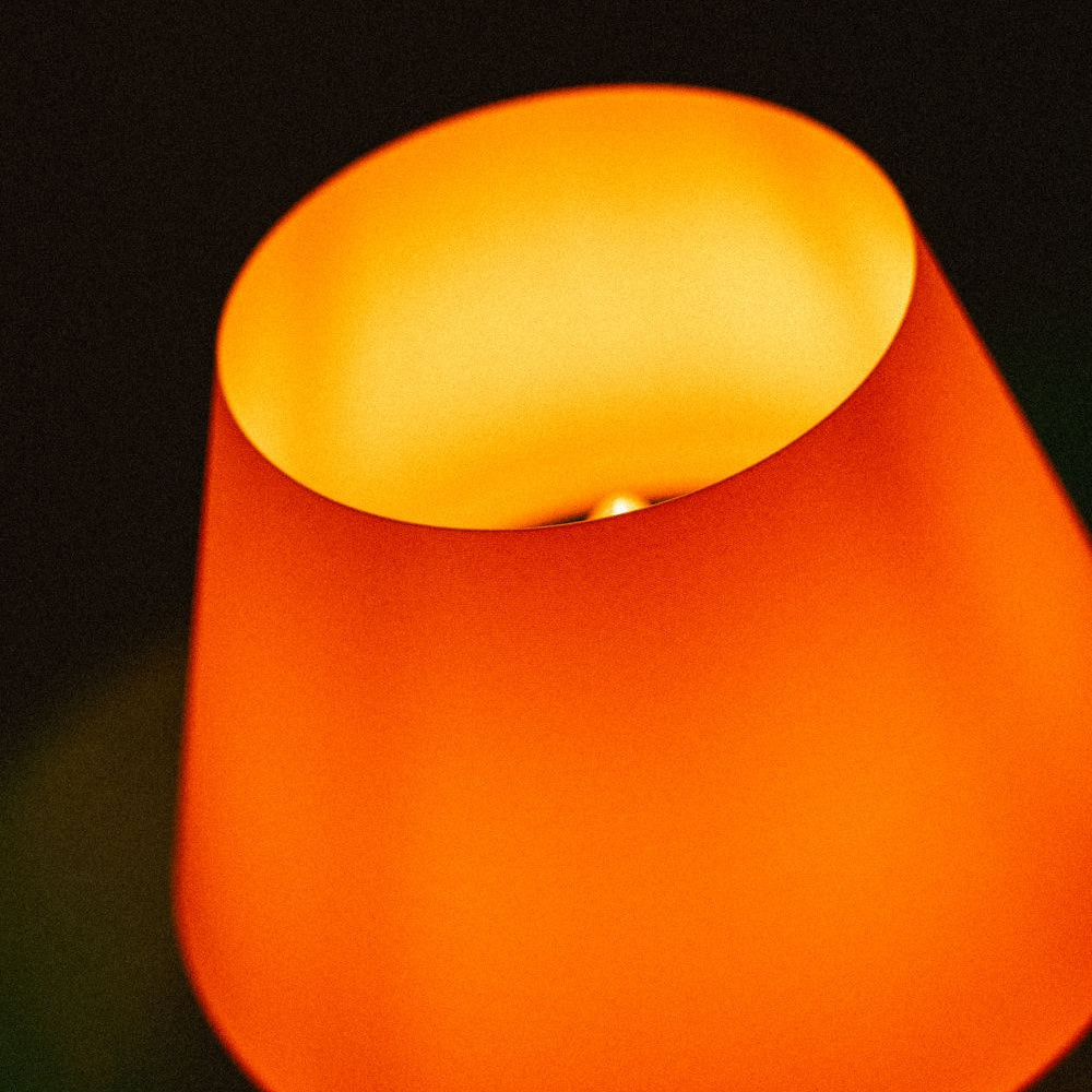Lámpara Fome Naranja de CuatroCeroTres, diseño moderno, visible en imagen, con base y pantalla naranja brillante.