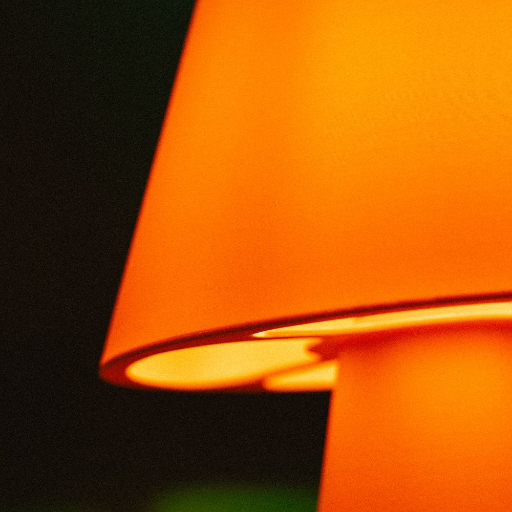 Lámpara Fome naranja de la marca CuatroCeroTres, con diseño moderno y base visible en la imagen.