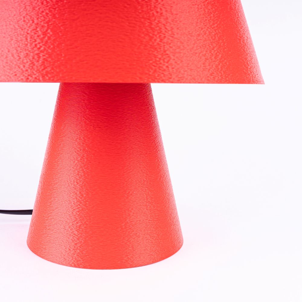 Lámpara Fome Roja de CuatroCeroTres iluminando con diseño moderno y base visible, en un fondo neutro.
