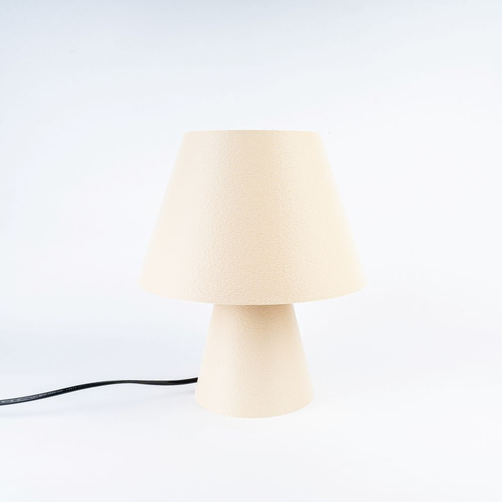 Lámpara beige CuatroCeroTres, estilo moderno, con base y pantalla en color beige, sobre una mesa de madera.